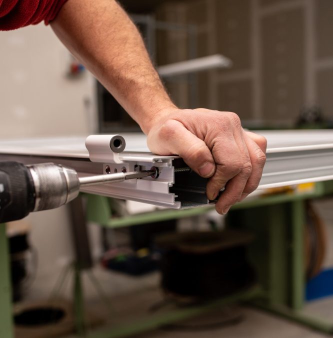 A male with a red shirt making a window with industrial tools